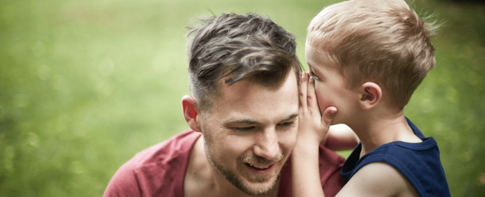 Un fils chuchote à l'oreille de son père