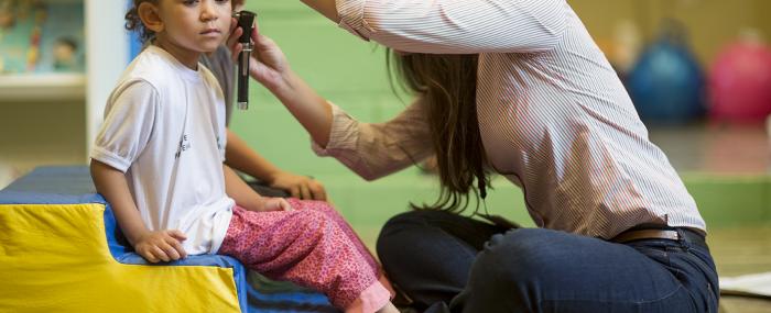 Médecin auscultant l'oreille d'une enfant