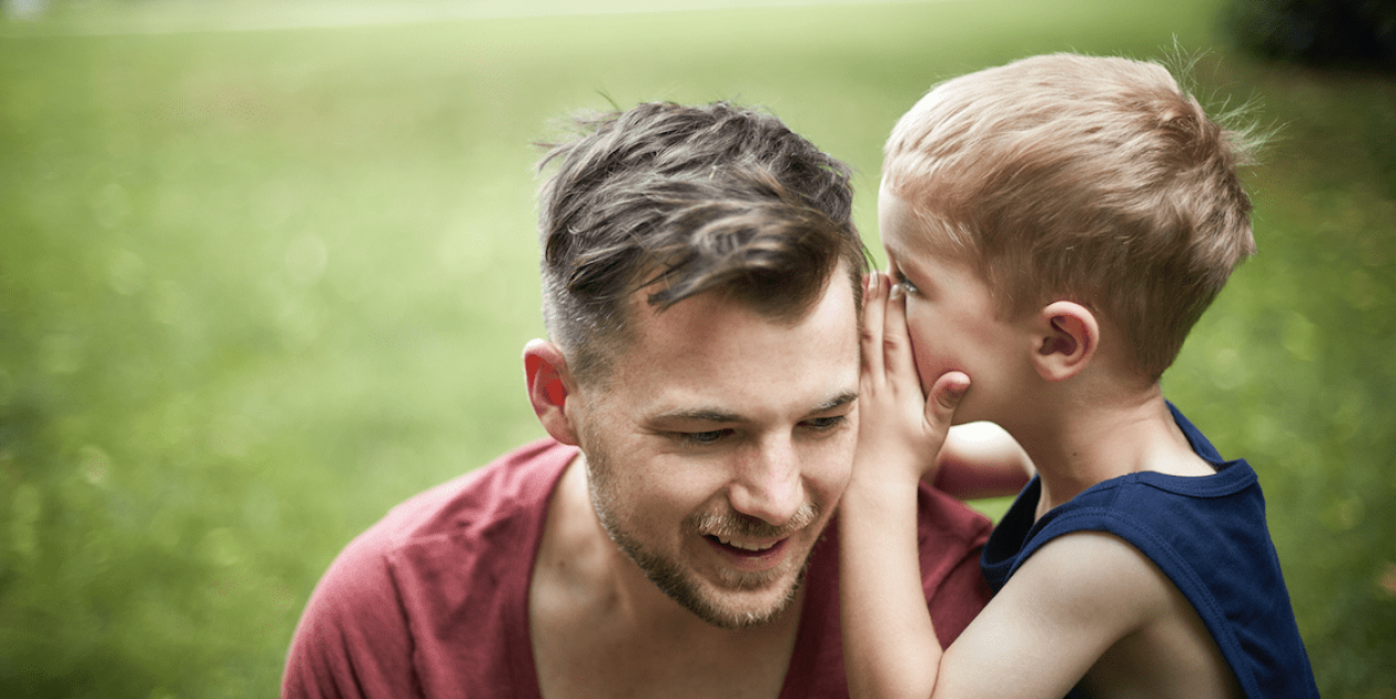 Un fils chuchote à l'oreille de son père