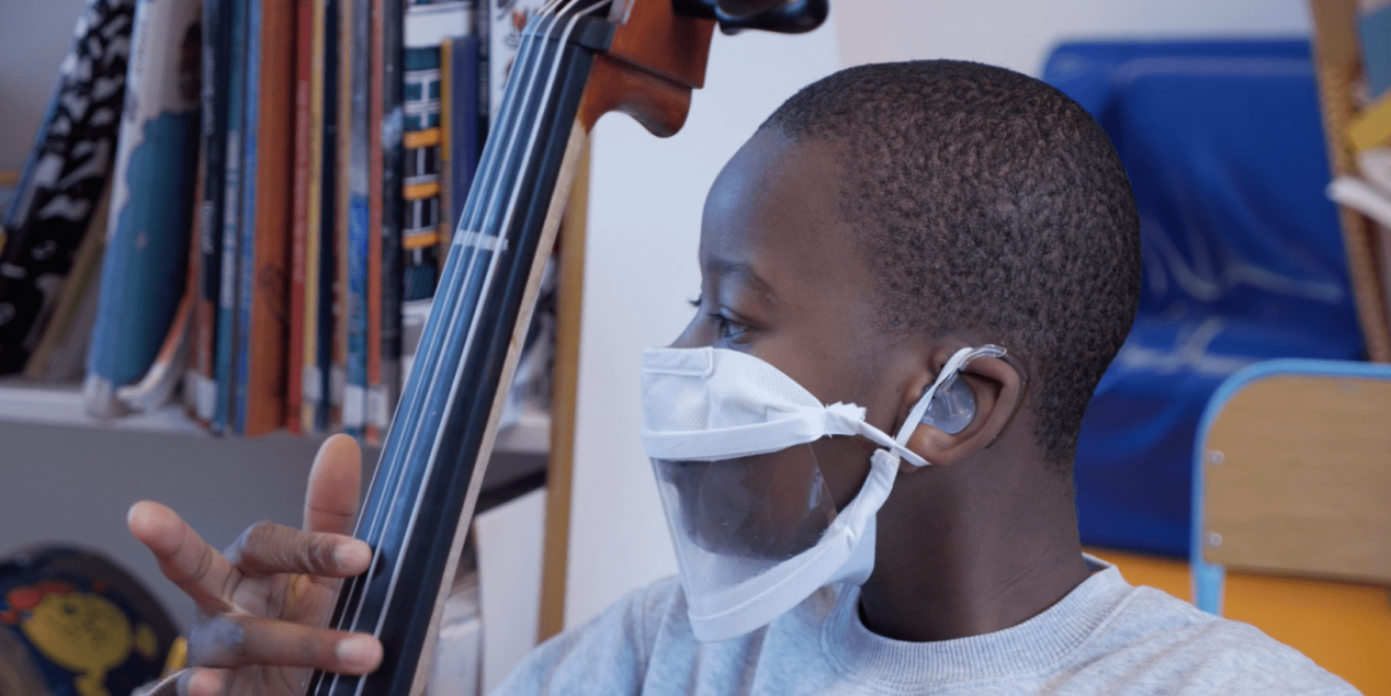 Un élève sourd appareillé qui joue du violoncelle