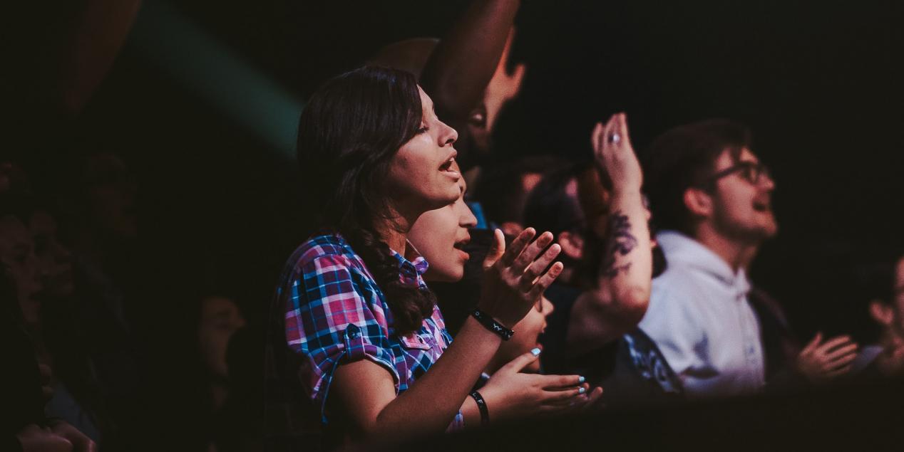 Des personnes qui chantent et applaudissent à un concert