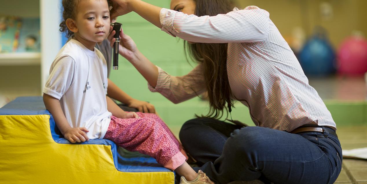 Médecin auscultant l'oreille d'une enfant